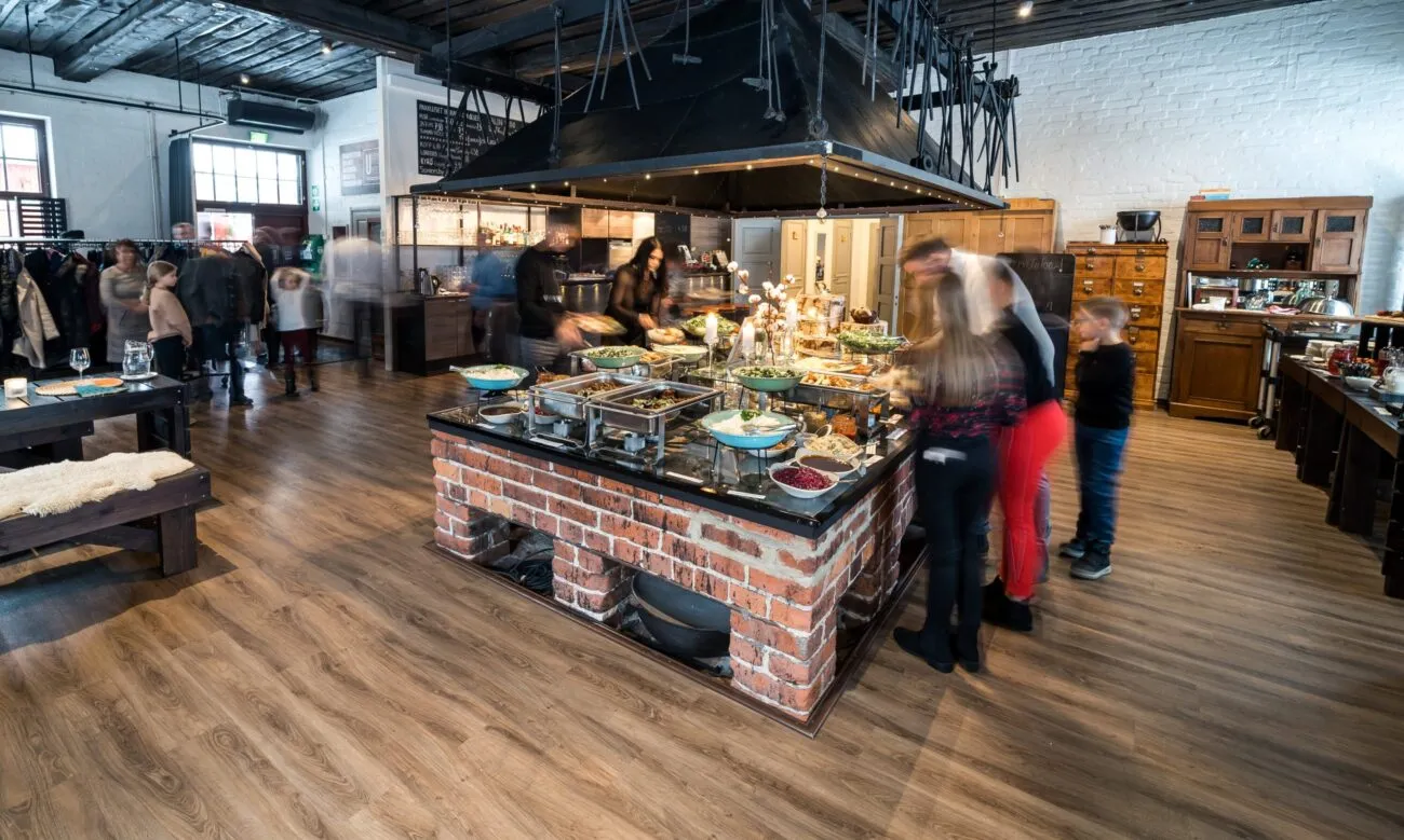 Buffet-tyylinen ruoka-alue, jossa on monia herkullisia vaihtoehtoja, vilkas tunnelma ja asiakkaita nauttimassa ruoasta.