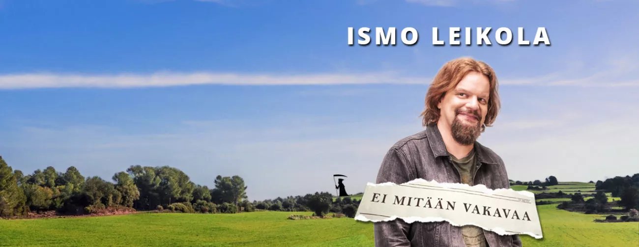 Ismo Leikola seisoo vihreiden peltojen edessä, taustalla kirkas taivas ja tekstillä "EI MITÄÄN VAKAVAA".
