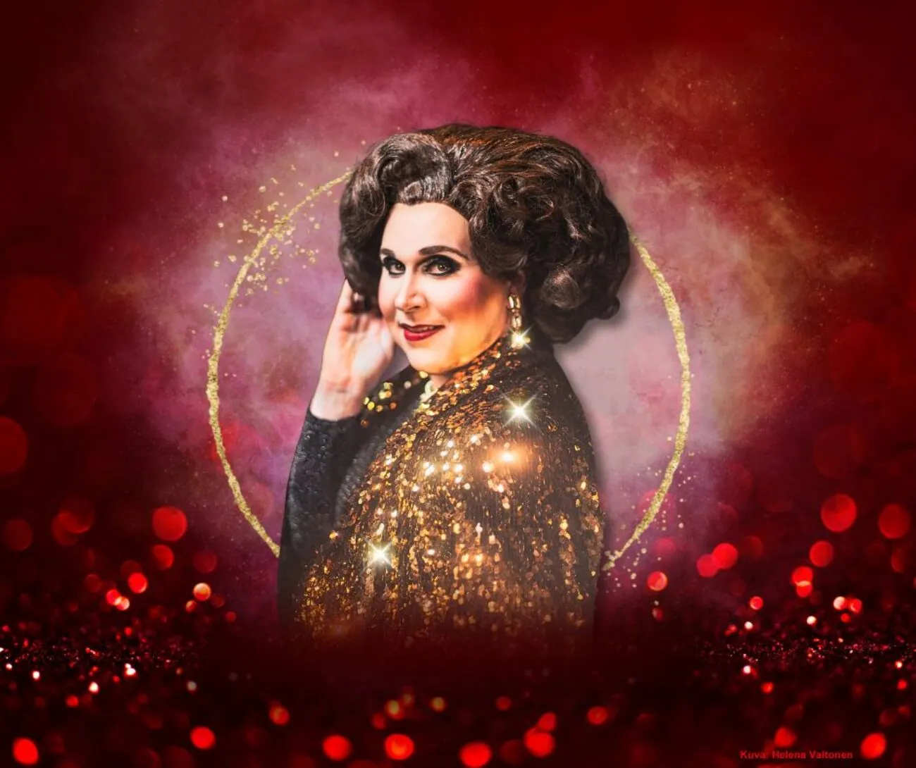 Energinen drag-esitys, jossa henkilö näyttää näyttäviä vaatteita ja glamouria punaisessa, kimaltelevassa ympäristössä.